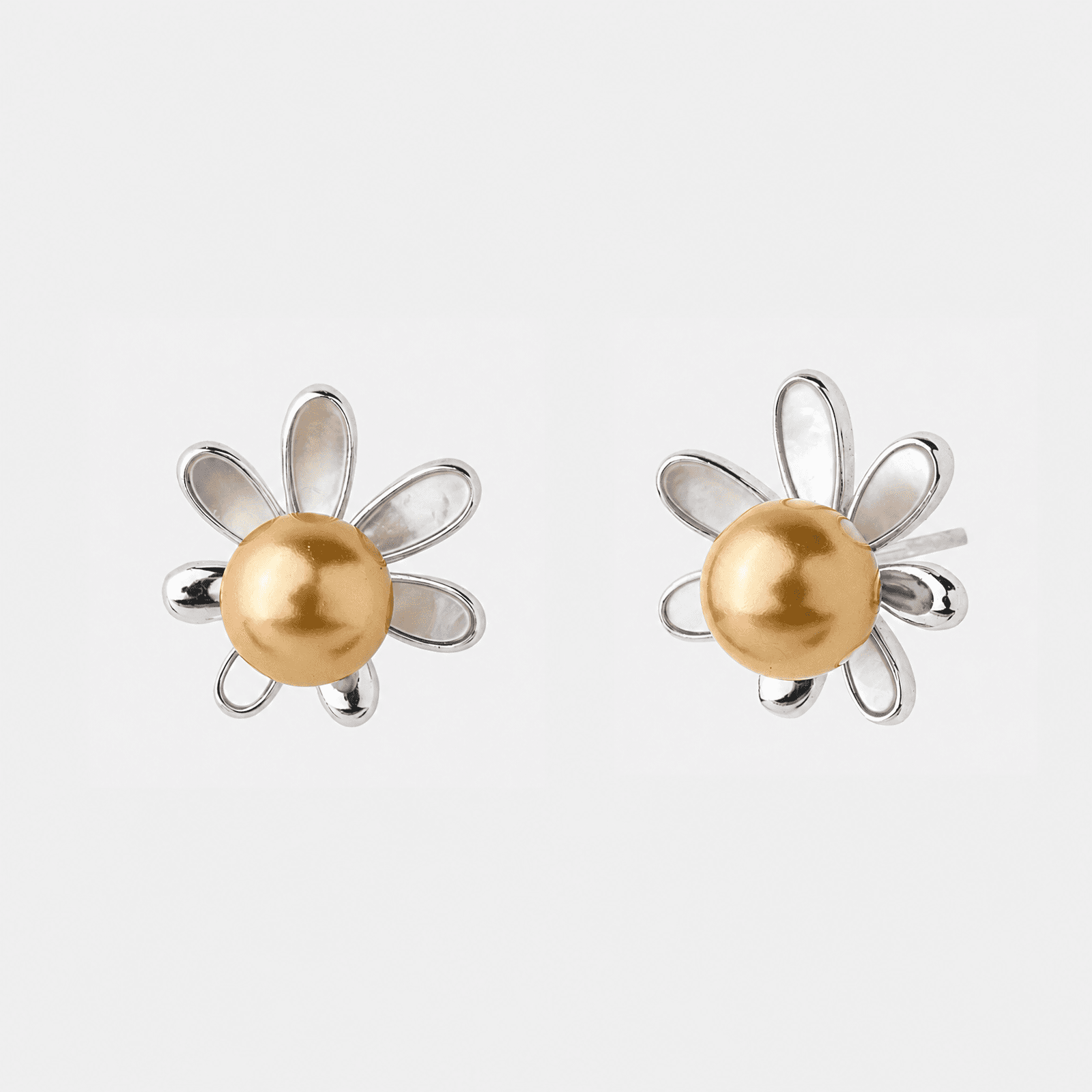 Pearl stud earrings displayed on a warm jewelry surface